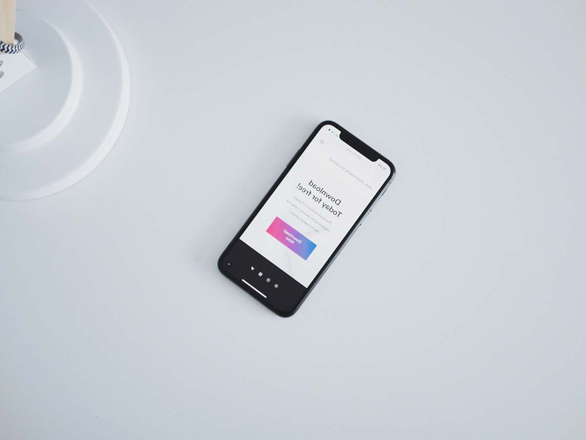 mobile phone turned on iPhone X on white surface tech